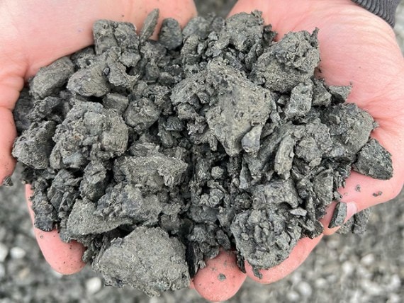 Two hands holding 1 1/4" minus crushed rock