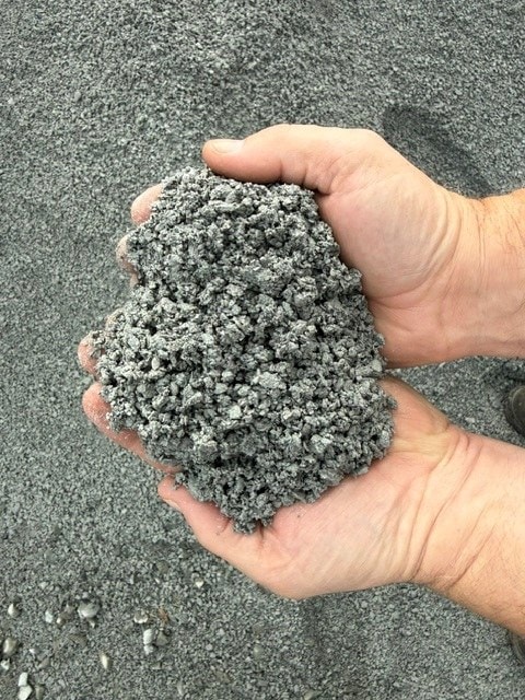 Two hands holding 1/4" paver minus