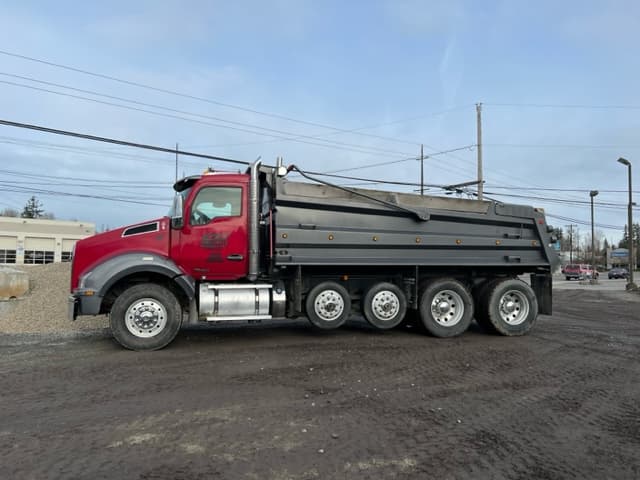 A red DC Materials dump truck seen from the side
